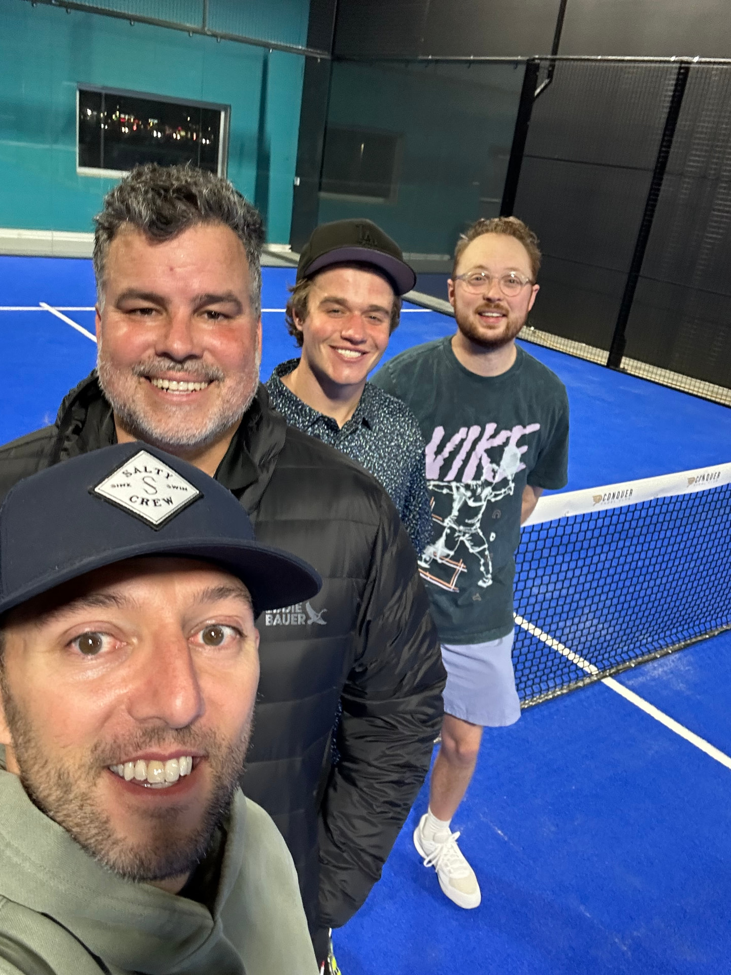 Mike Manzella and three players on an indoor blue padel court